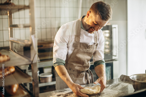 фотографія Man kneads the dough for bread