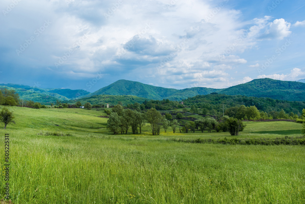 Idyllic landscape with fresh green meadows and mountain tops in the background, in the beautiful surroundings of the Malo Bonjince, Serbia Idyllic landscape with fresh green meadows and mountain tops in the background, in the beautiful surroundings of the Malo Bonjince, Serbia