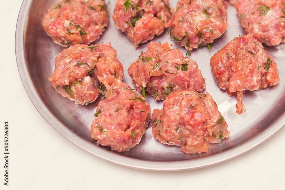 Fototapeta premium Prepared raw lumps of minced meat on a metal tray. Top view close up.