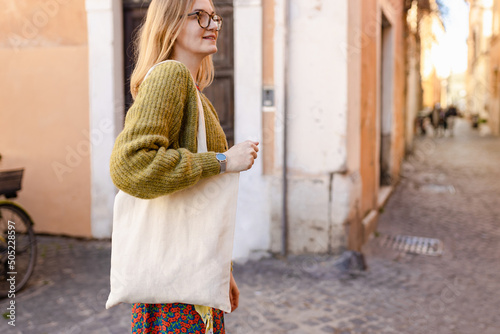 Obraz na płótnie Young Girl holding white cotton tote bag on old town background. Mockup and zero waste concept. Eco Nature Friendly Style. Environmental Conservation Recycling mock up w salonie