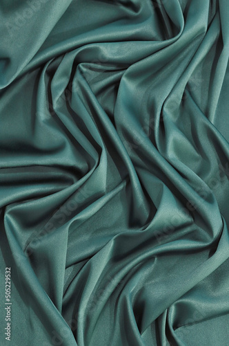 The texture of the fabric. green delicate silk, silk fabric.
