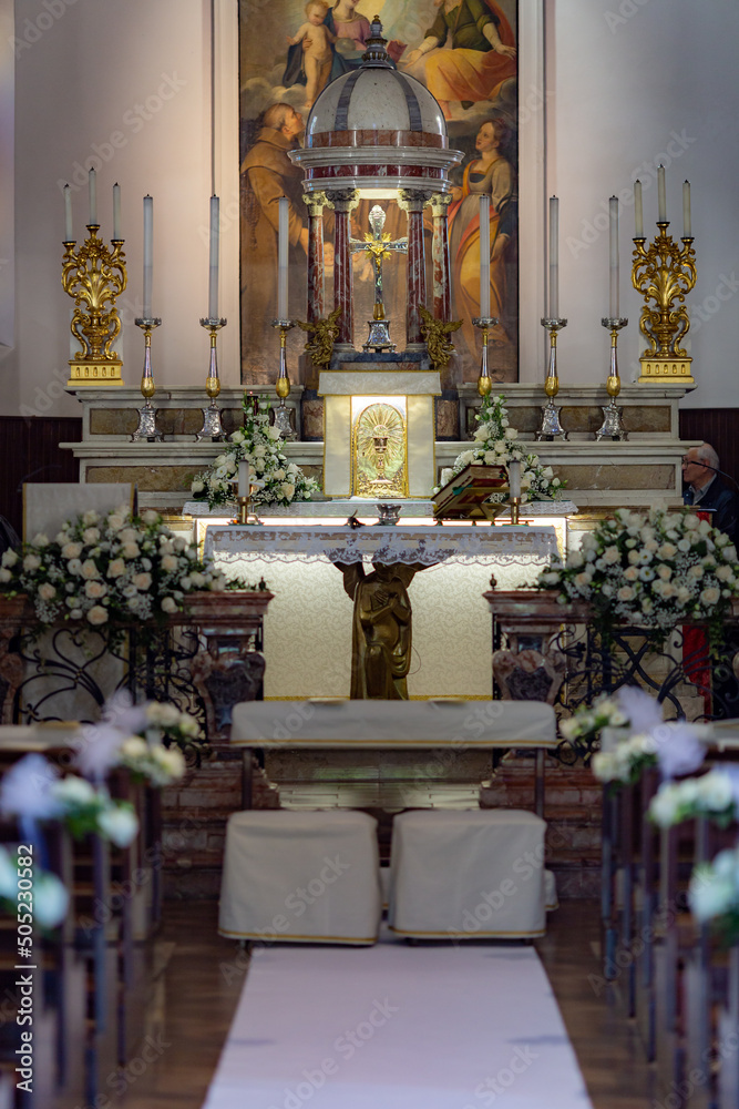 front view of an altar of a catholic church decorated for a wedding
