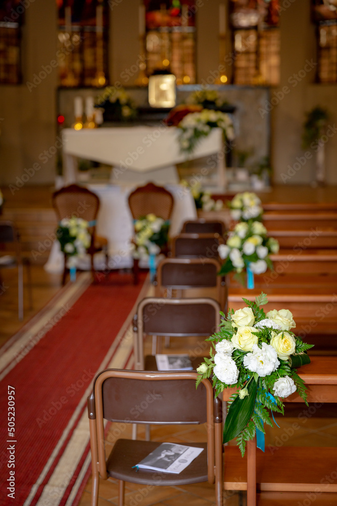 Flower decorations composed of sunflowers on the benches of a catholic church. 