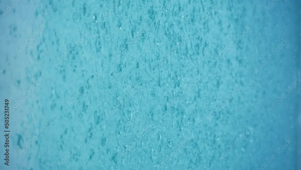 Vertical video - Rain Water Droplets Splash into a Blue Puddle. Slow motion close up of rain hitting a puddle during a storm in rainy season Vertical video - Rain Water Droplets Splash into a Blue Puddle. Slow motion close up of rain hitting a puddle during a storm in rainy season