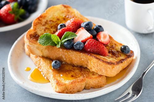 Fotografija French toast with honey and berries on plate