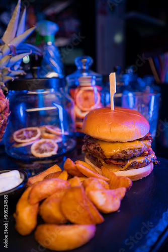 Burger and fries with fruit around it