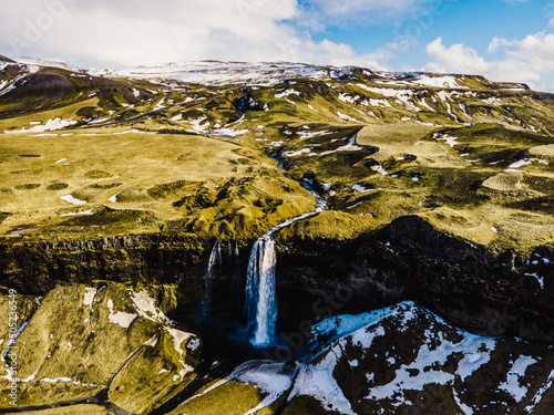 Seljalandsfoss is located in the South Region on Iceland. Visitors can walk behind. Seljalandsfoss waterfall with a great sunset on popular tourist destination. Part of the golden circle