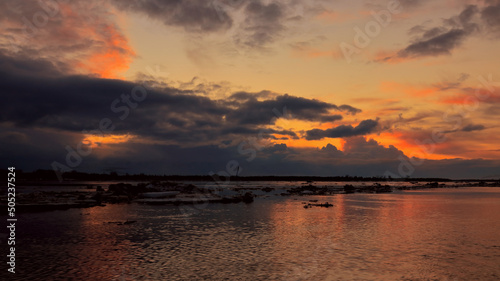 Dramatic sunset over the river surface with floating ice floes. spring landscape © Aleksandr 44ARH
