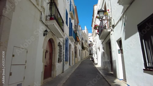 Walking on a narrow street in Sitges, Costa Dorada in Catalonia, spain photo