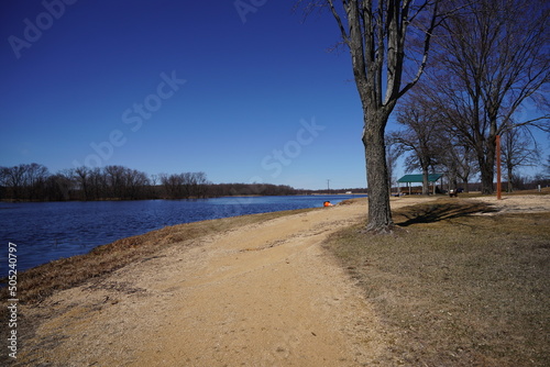 Fototapeta Naklejka Na Ścianę i Meble -  Dirt walking path along a lake during early spring.
