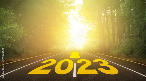 The word 2023 written on forest road. Concept for new year 2023. The route to the new year indicated by the arrow. Anniversary planning for hope and future concept