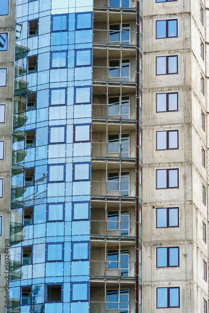 construction of a modern high-rise building, the creation of a concrete frame, building materials and a construction crane