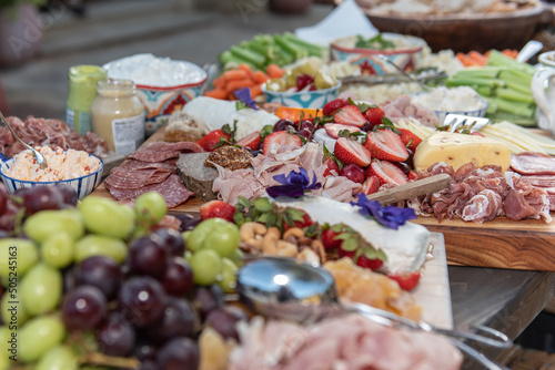 Sliced strawberries are at the center of this delicious buffet charcuterie board for the hungry guests