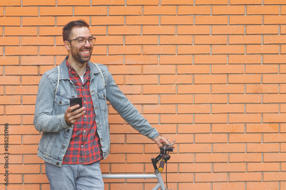 Smiling young man standing in front of brick wall Smiling young man standing in front of brick wall