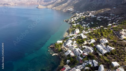 Aerial backwards reveal footage of Massouri village on Kalymnos island on sunny day. Aegean Sea, Greece. photo