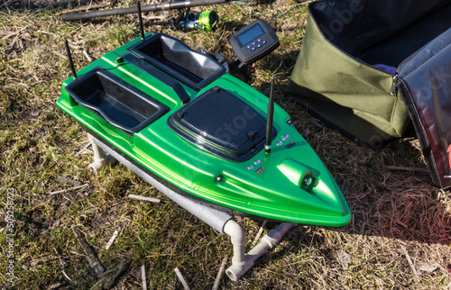 Bait Boat. A green fishing feeder with a wireless remote controller, fishfinder boat.  photo