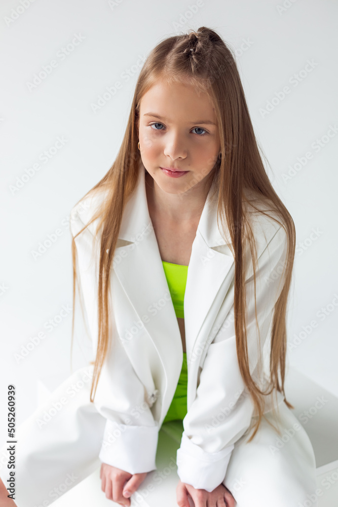 Stylish fashionable joyful young girl in elegant suit and sport wear on white background Stylish fashionable joyful young girl in elegant suit and sport wear on white background