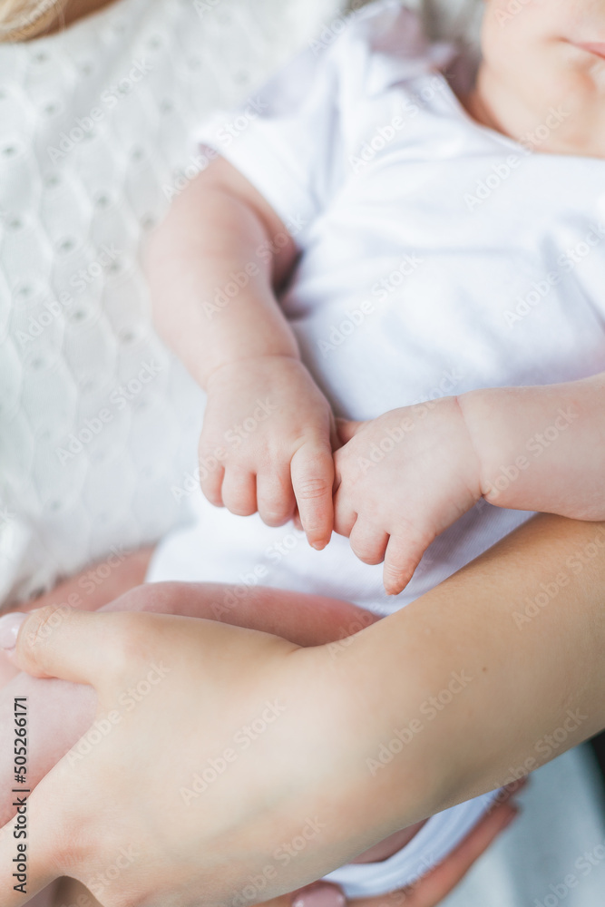 Young beautiful mother with blue eyes holds her little newborn daughter in her arms. Motherhood. Care. Baby. Young beautiful mother with blue eyes holds her little newborn daughter in her arms. Motherhood. Care. Baby.