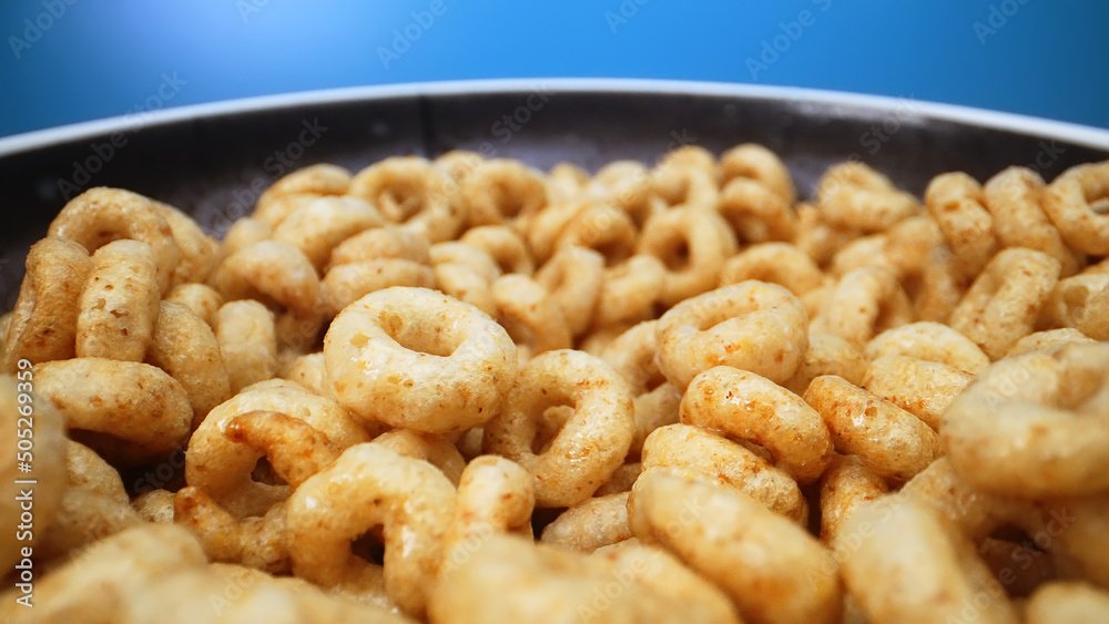 Bowl with cereal circles on blue background. Bowl with cereal circles on blue background.