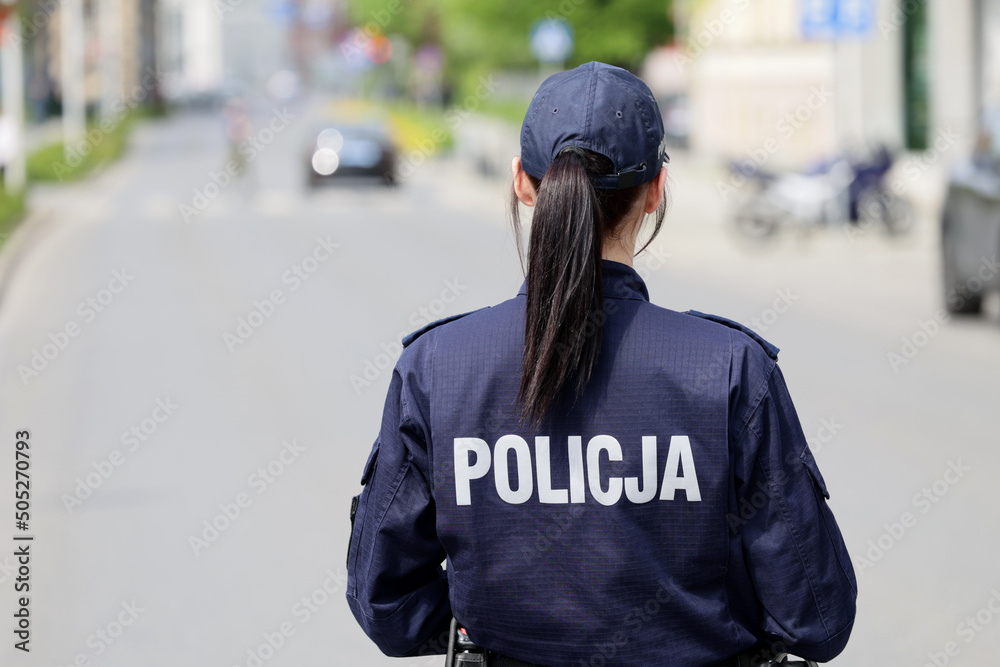 Policjantka w niebieskim mundurze podczas pracy w mieście. - obrazy, fototapety, plakaty 