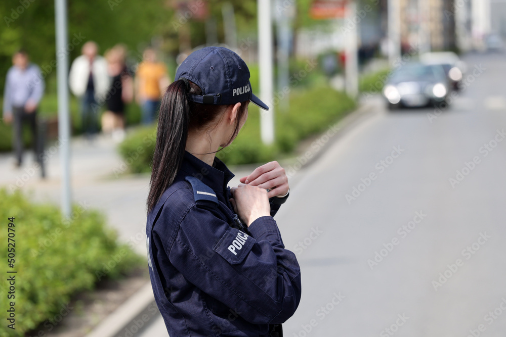 Policjantka w niebieskim mundurze podczas pracy w mieście. - obrazy, fototapety, plakaty 