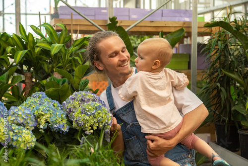 father and daughter are selecting plants for planting