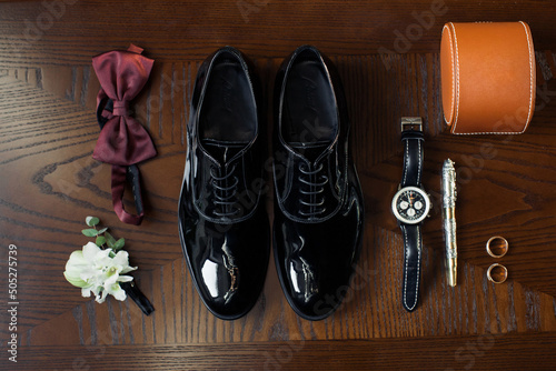 Wedding black shoes and accessories on the wooden table