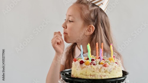 Happy Birthday. Party. Funny child eats cake and soils face and hands. Cute girl bites a holiday cake and licks his fingers photo