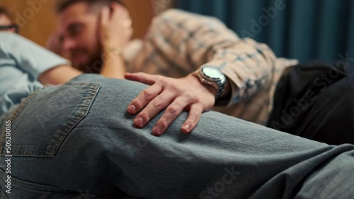 A young couple lies in bed in a hotel room and strokes each other