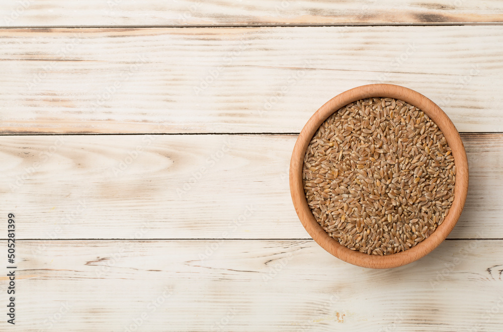 Wholegrain spelt farro in bowl on wooden background. Top view Wholegrain spelt farro in bowl on wooden background. Top view
