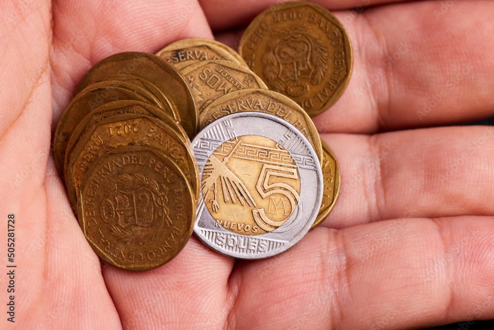 Several and different value coins from Perú in hands Several and different value coins from Perú in hands