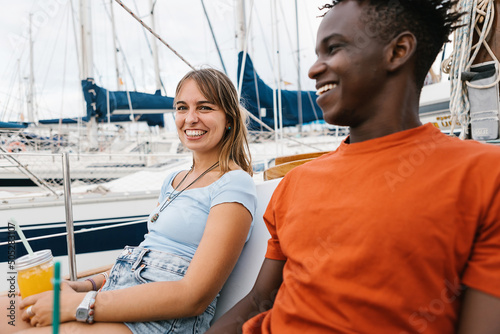 Happy multiracial couple having fun outdoors on a boat - African american man enjoying holidays with girlfriend - Relationship and summer vacation concept.