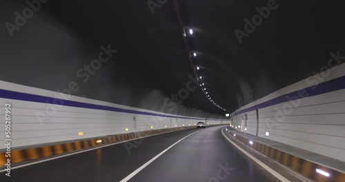 Driving car in a tunnel. Words in the footage means speed limitation at 80km per hour, the tunnel's name  photo