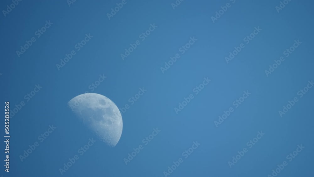 Static colorfull view of the growing moon in the blue daytime sky, large craters are visible. High quality footage Static colorfull view of the growing moon in the blue daytime sky, large craters are visible. High quality footage
