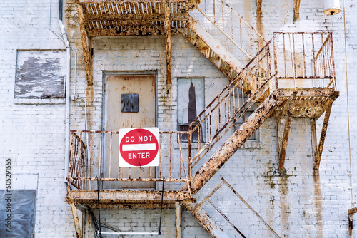 Very rusty exterior stairwell on a building with a do not enter sign photo