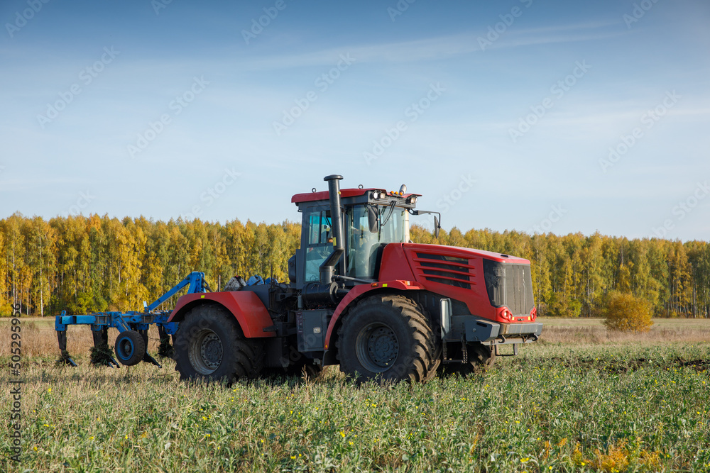 Fototapeta premium The tractor plows the land. Agriculture image