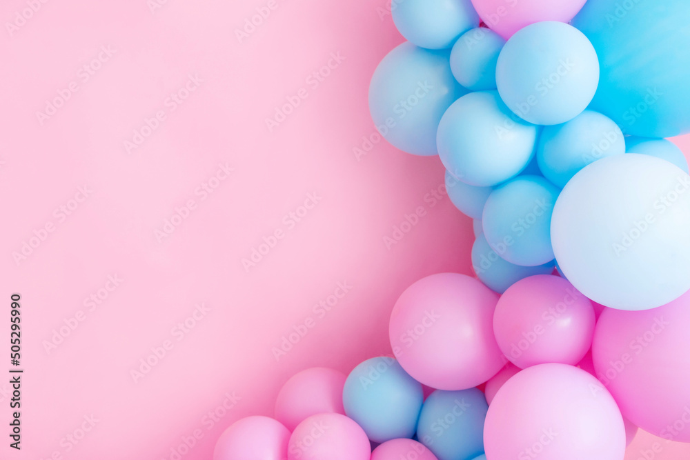Blue and pink balloons on a pink background with copy space.