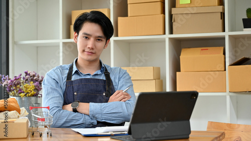 Handsome Asian millennial SME startup business male owner sitting at his office desk