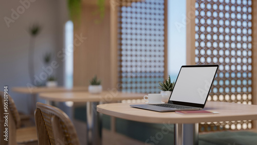 Modern restaurant or coffee shop seating area interior design with a portable laptop © bongkarn