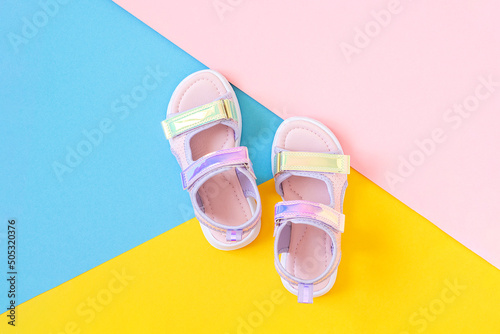 Stylish holographic sandals for kids on colored background. Shiny fashion summer shoes. Flat lay, Top view