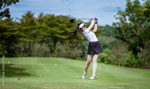 Professional woman golfer teeing golf in golf tournament competition at golf course for winner