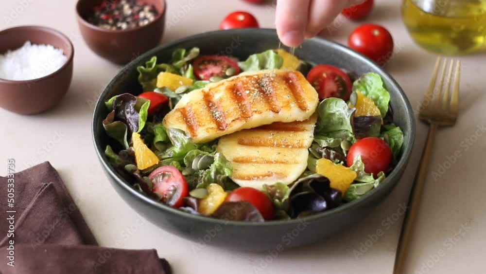 Salad with grilled halloumi cheese, tomatoes, orange and pumpkin seeds. Healthy eating. Vegetarian food. Keto diet. Salad with grilled halloumi cheese, tomatoes, orange and pumpkin seeds. Healthy eating. Vegetarian food. Keto diet.