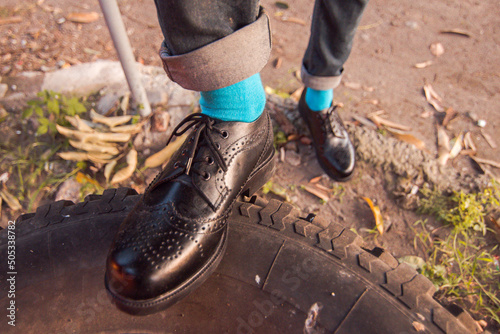 Full black brogue wingtip shoes with upper genuine leather and outsole loafers worn by men outdoors on a warm sunset photo