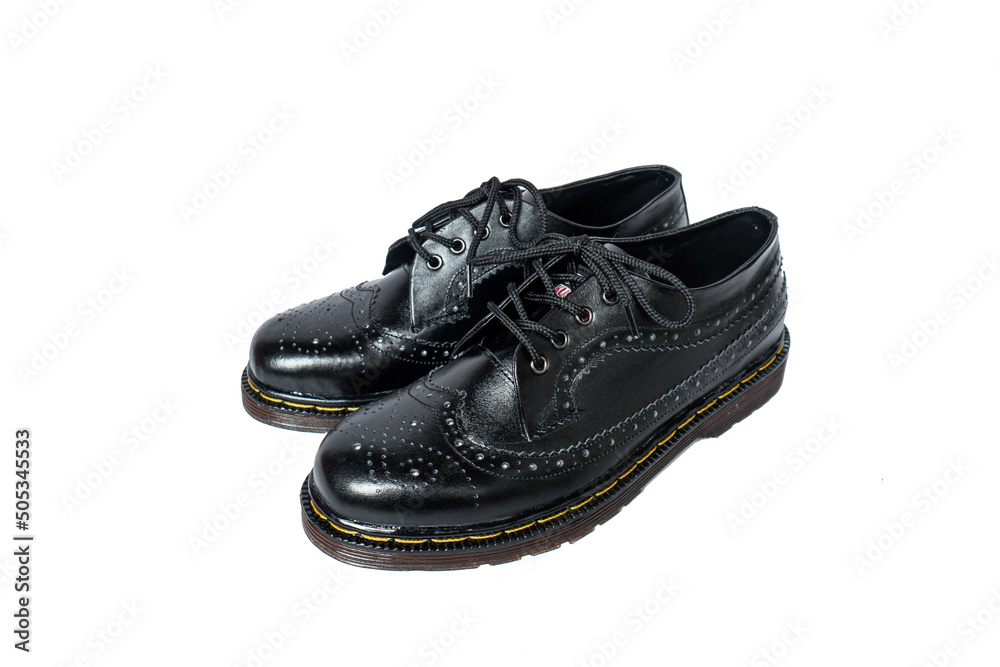 Full black brogue wingtip shoes made of genuine cowhide with a detailed pattern on a white background Full black brogue wingtip shoes made of genuine cowhide with a detailed pattern on a white background