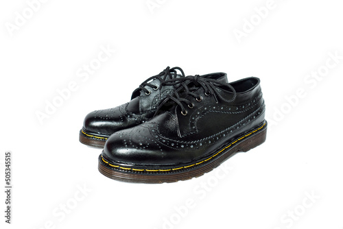 Full black brogue wingtip shoes made of genuine cowhide with a detailed pattern on a white background