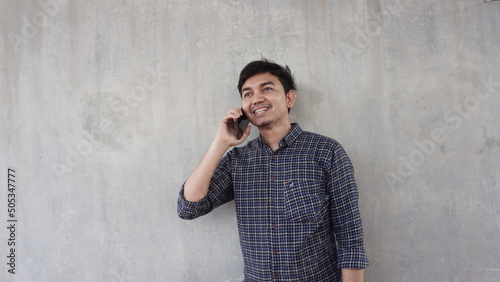 young asian man calling with happy expression photo