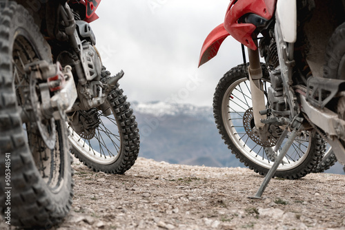 Two enduro cross motorbikes parked in mountains