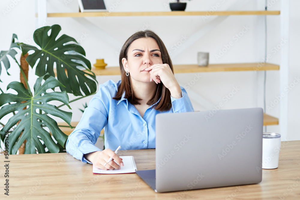 Concentrated businesswoman is doing paperwork while sitting with a laptop at the table at home, focused senior employee preparing documents, checking bills working remotely at home Concentrated businesswoman is doing paperwork while sitting with a laptop at the table at home, focused senior employee preparing documents, checking bills working remotely at home
