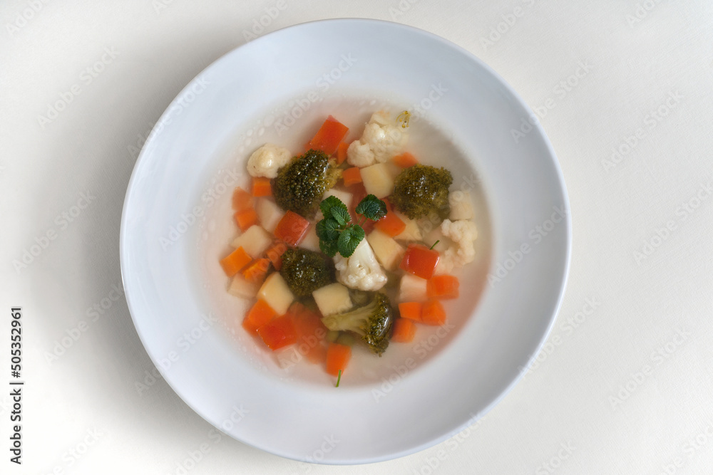 Healthy eating. Dietary food. Dietary vegetable soup with a broccoli and cauliflower in a plate isolated on a white background Healthy eating. Dietary food. Dietary vegetable soup with a broccoli and cauliflower in a plate isolated on a white background