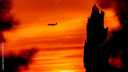 Israeli air force plane flying across the dramatic red skies during sunset- Israel